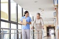 Asian old woman walking with a walker in rehab center