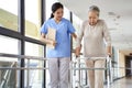 Asian old woman walking with a walker in rehab center