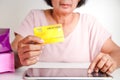 An elderly woman with a mock up credit card
