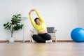Asian overweight woman doing stretching exercise at home on fitness mat. Home activity training, online fitness class. Stretching Royalty Free Stock Photo