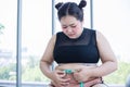 Asian overweight woman measuring fat layer with waistline at home Royalty Free Stock Photo
