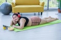 Asian overweight woman using tablet and. wearing headphone for listening music and She is exercising at home ,Asian girl enjoy