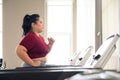 Asian overweight women in sportswear running on treadmill in fitness club. Weight loss workout, healthy lifestyle concept Royalty Free Stock Photo