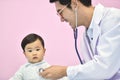 Asian paediatrician examining a baby with a stethoscope Royalty Free Stock Photo