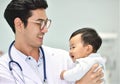 Asian paediatrician is taking care of baby