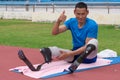 an Asian paralympic athlete, sporting two prosthetics running blades, presents a thumbs up, signaling readiness to start his
