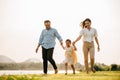 Asian family walking and holding hands in a beautiful springtime park