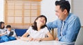 Asian parents homeschooling their children at home. Father teach daughter using laptop computer Royalty Free Stock Photo