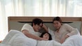 Asian parents are lull their daughters to sleep in bed in the bedroom.