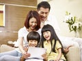 Asian family with two children using digital tablet together Royalty Free Stock Photo