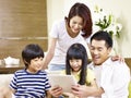 Asian family with two children using digital tablet together Royalty Free Stock Photo