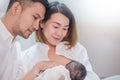 Asian parents with newborn baby being breastfeeding, Close up portrait of asian young couple father mother holding new born baby.