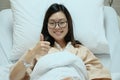 Beautiful Asian patient girl thumbs up and smile on hospital admission bed, medical or health concept Royalty Free Stock Photo