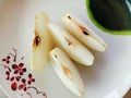 Asian pear Pyrus Pyrifolia with slices on plate background closeup.