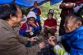 Asian peasants, farmers, villagers, sit around fire, at rural c