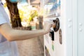 Asian people buying hygienic drinking water from automatic water dispenser,hand of child girl is inserting coin in to drinks Royalty Free Stock Photo