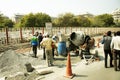 Asian people and Indian workers with heavy machinery working builder new footpath at construction site in New Delhi, India