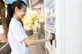 Asian people paying or buying hygienic drinking water from automatic vending machine in area lacking clean water,student inserting