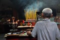 Asian people praying and burning incense sticks in a pagoda Royalty Free Stock Photo