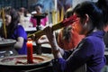 Asian people praying and burning incense sticks in a pagoda Royalty Free Stock Photo