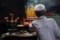 Asian people praying and burning incense sticks in a pagoda Royalty Free Stock Photo