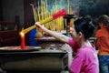 Asian people praying and burning incense sticks in a pagoda Royalty Free Stock Photo