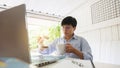Asian people 30s drinking coffee and relaxing after looking  new trading  platforms stock tickers or graphs ,economics worker at Royalty Free Stock Photo