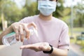 Asian people using alcohol antiseptic gel and wearing prevention mask,prevent against infection of Covid-19 outbreak,woman washing