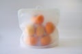 Asian persimmons stored in reusable silicone bag, to keep them fresh. Storing fruits fresh in reusable bags instead of plastic is