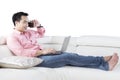 Asian person with laptop on couch Royalty Free Stock Photo