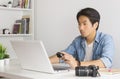 Asian Photographer or Freelancer Checking File in Action Camera with Laptop in Home Office Royalty Free Stock Photo