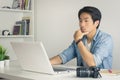 Asian Photographer or Freelancer Work from Home Serious Check Photo in Laptop at Home Office in Vintage Tone