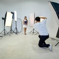 An Asian photographer is photographing a model posing in the studio Royalty Free Stock Photo