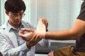Asian physiotherapists are examining the results of wrist surgery of patients