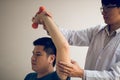 Asian physiotherapists help raise arms for patients to raise dumbbells through his rehabilitation in the clinic Royalty Free Stock Photo