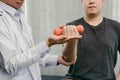 Asian physiotherapists are helping patients lift dumbbells for arm recovery Royalty Free Stock Photo