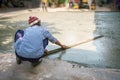 Plasterer man hand spreading adjust concrete cement on the floor