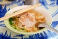 Asian pork noodle soup in a bowl with short spoon and wooden chopsticks Royalty Free Stock Photo