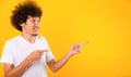Asian Portrait happy young man curly hair pointing fingers away copy space Royalty Free Stock Photo