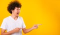Asian Portrait happy young man curly hair pointing fingers away copy space Royalty Free Stock Photo