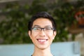 Asian positive cheerful young man in glasses