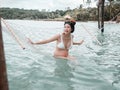 Asian pregnant woman in bikini sitting on hammock in turquoise sea water near beach. tropical beach in Koh Kut Island, Thailand. p Royalty Free Stock Photo