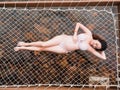 Asian pregnant woman in bikini sitting on hammock in turquoise sea water near beach. tropical beach in Koh Kut Island, Thailand. p Royalty Free Stock Photo