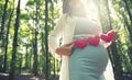 Asian pregnant woman in blue dress in the florest background holding heart shape accessories Royalty Free Stock Photo