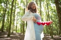 Asian pregnant woman in blue dress in the florest background holding heart shape accessories Royalty Free Stock Photo