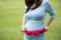 Asian pregnant woman in blue dress holding heart shape accessories Royalty Free Stock Photo