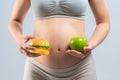 Asian pregnant woman choose healthy food or junk food Royalty Free Stock Photo