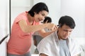 Asian Pregnant Woman cutting husband hair with clipper at home Royalty Free Stock Photo