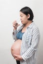 Asian pregnant woman drinking water, isolated on white background Royalty Free Stock Photo