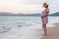 Asian Pregnant woman embracing touching her belly relaxing at the beach outdoor Royalty Free Stock Photo